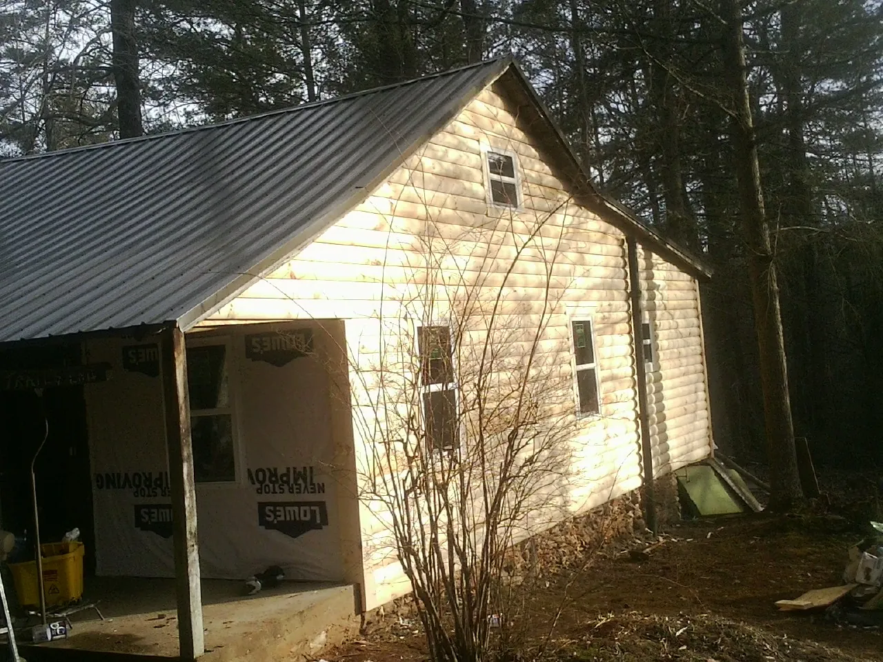 Log siding gable end under a dark metal roof edge in Bloomington