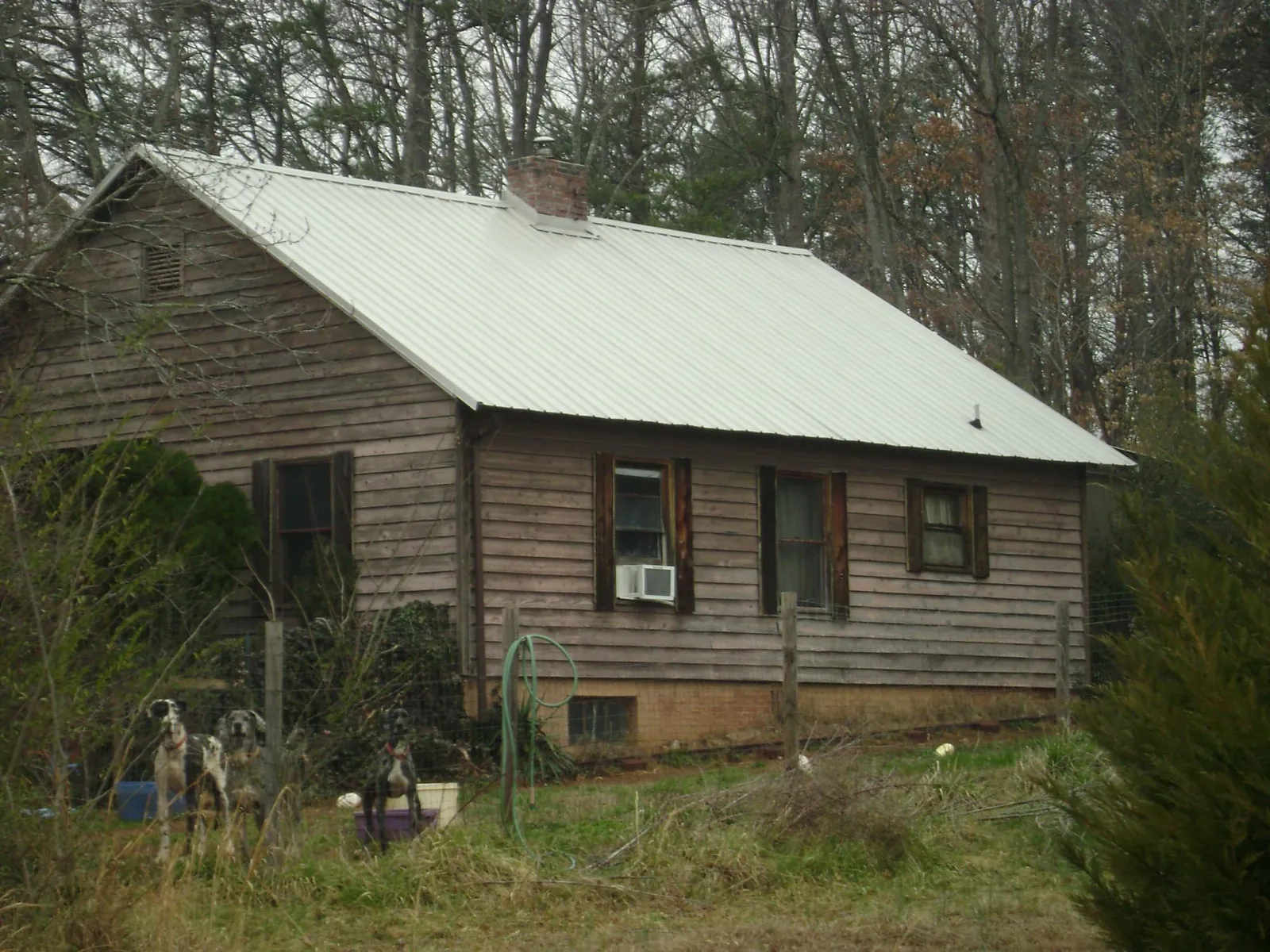 White metal roof on an old wood sided farmhouse, from a Metal Roof Installation job in Bloomington